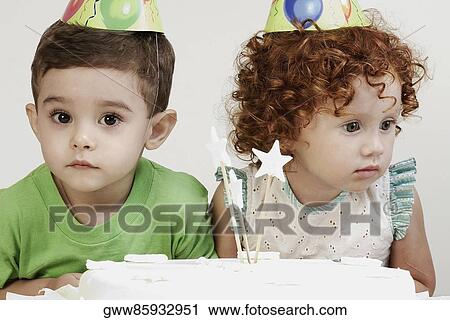 Close-up of a girl and a boy wearing birthday hats View Large Photo Image Stock Image - Close-up of a girl and a boy wearing birthday hats. Fotosearch