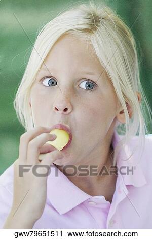 Stock Image - Close-up of a girl eating an ice-cream. Fotosearch