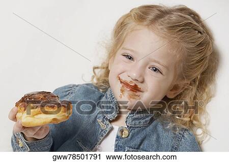 Close-up of a girl eating cake and smiling View Large Photo Image Stock Image - Close-up of a girl eating cake and smiling. Fotosearch