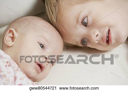 Close-up of a girl looking at her sister View Large Photo Image Stock Image - Close-up of a girl looking at her sister. Fotosearch