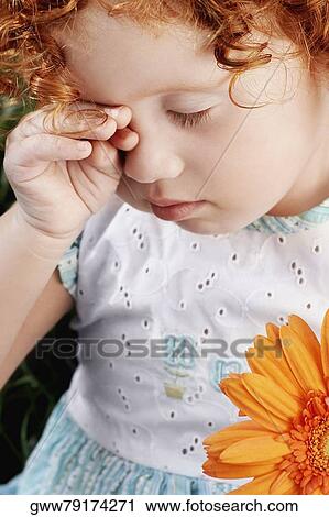 Close-up of a girl rubbing her eyes View Large Photo Image Stock Image - Close-up of a girl rubbing her eyes. Fotosearch