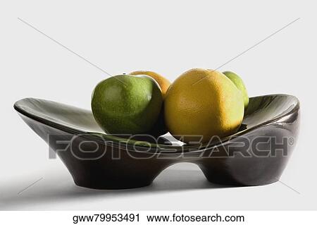 Close-up of a granny smith apple and an orange on a platter View Large Photo Image Stock Image - Close-up of a granny smith apple and an orange on a platter. Fotosearch
