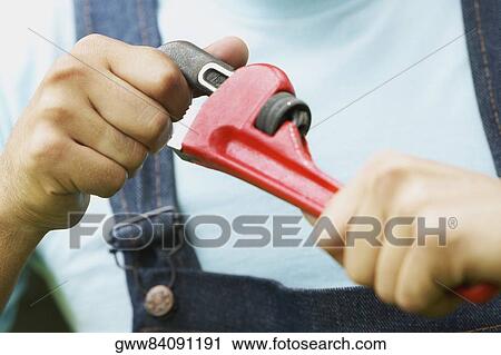 Close-up of a man holding an adjustable wrench View Large Photo Image Stock Image - Close-up of a man holding an adjustable wrench. Fotosearch