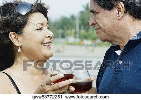 Close-up of a mature couple toasting with wine glasses View Large Photo Image Stock Image - Close-up of a mature couple toasting with wine glasses. Fotosearch