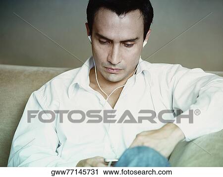 Close-up of a mature man listening to an MP3 player View Large Photo Image Stock Image - Close-up of a mature man listening to an MP3 player. Fotosearch