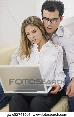 Close-up of a mid adult couple using a laptop View Large Photo Image Stock Image - Close-up of a mid adult couple using a laptop. Fotosearch