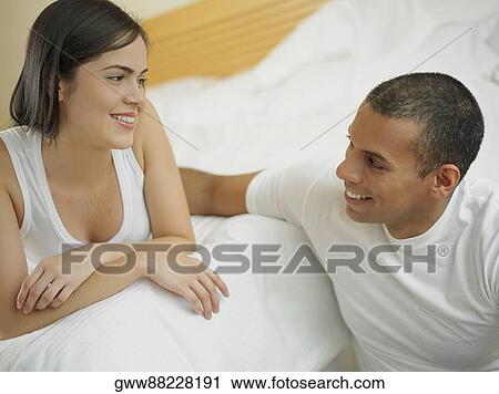 Close-up of a mid adult man and a young woman looking at each other and smiling View Large Photo Image Stock Image - Close-up of a mid adult man and a young woman looking at each other and smiling. Fotosearch