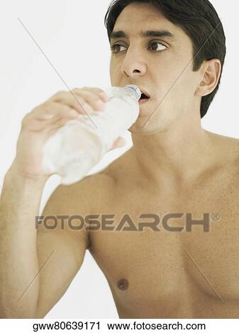 Stock Image - Close-up of a mid adult man drinking water from a water bottle. Fotosearch