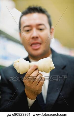 Close-up of a mid adult man holding a dog bone View Large Photo Image Stock Image - Close-up of a mid adult man holding a dog bone. Fotosearch