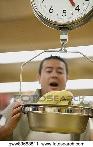 Close-up of a mid adult man looking at a weighing scale View Large Photo Image Stock Image - Close-up of a mid adult man looking at a weighing scale. Fotosearch
