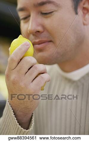 Close-up of a mid adult man smelling a lemon View Large Photo Image Stock Image - Close-up of a mid adult man smelling a lemon. Fotosearch