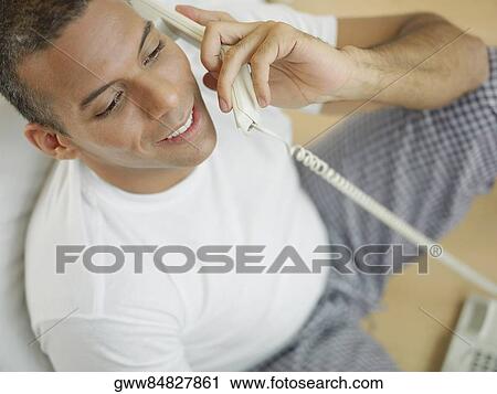 Close-up of a mid adult man talking on the telephone and smiling View Large Photo Image Stock Image - Close-up of a mid adult man talking on the telephone and smiling. Fotosearch