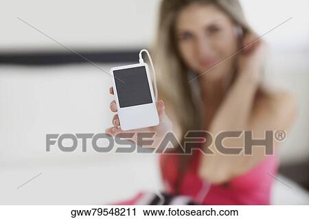 Stock Image - Close-up of a mid adult woman showing an MP3 player. Fotosearch