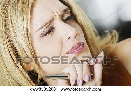 Close-up of a mid adult woman with her hand on her chin View Large Photo Image Stock Image - Close-up of a mid adult woman with her hand on her chin. Fotosearch