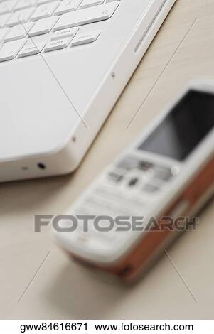 Close-up of a mobile phone with a laptop View Large Photo Image Stock Image - Close-up of a mobile phone with a laptop. Fotosearch