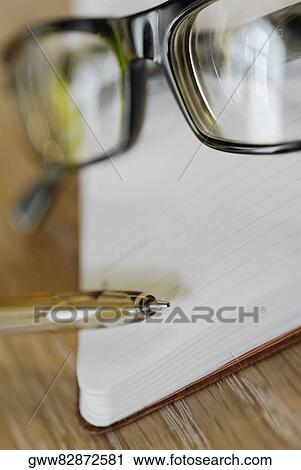 Close-up of a pair of eyeglasses with a pen and a diary View Large Photo Image Stock Image - Close-up of a pair of eyeglasses with a pen and a diary. Fotosearch