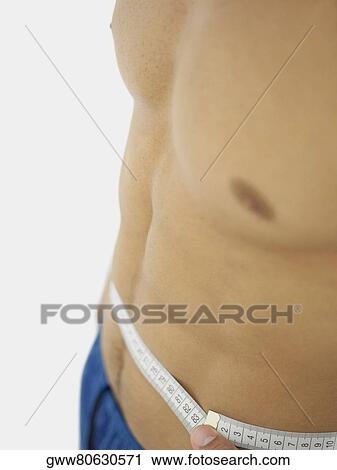 Close-up of a person measuring his waist with a tape measure View Large Photo Image Stock Image - Close-up of a person measuring his waist with a tape measure. Fotosearch