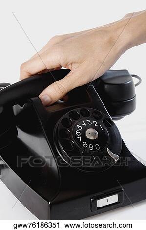 Stock Image - Close-up of a person's hand holding a telephone receiver. Fotosearch