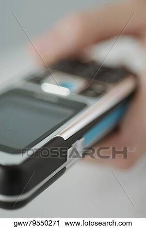 Close-up of a person's hand holding a mobile phone View Large Photo Image Stock Image - Close-up of a person's hand holding a mobile phone. Fotosearch