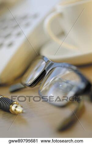 Close-up of a tea cup with a pen and a pair of eyeglasses View Large Photo Image Stock Image - Close-up of a tea cup with a pen and a pair of eyeglasses. Fotosearch