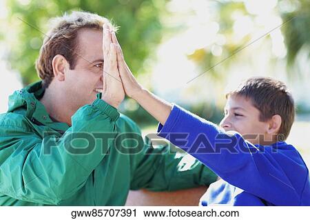Close-up of a teenage boy giving hi-five to his father View Large Photo Image Stock Image - Close-up of a teenage boy giving hi-five to his father. Fotosearch