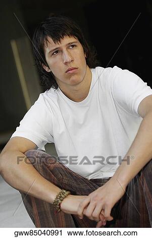 Close-up of a teenage boy sitting with his hands on his knees View Large Photo Image Stock Image - Close-up of a teenage boy sitting with his hands on his knees. Fotosearch