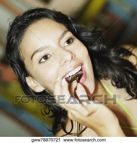 Stock Image - Close-up of a teenage girl eating a piece of fish. Fotosearch