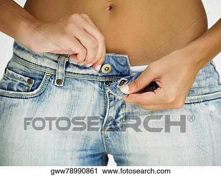 Close-up of a woman's hands buttoning her jeans View Large Photo Image Stock Image - Close-up of a woman's hands buttoning her jeans. Fotosearch