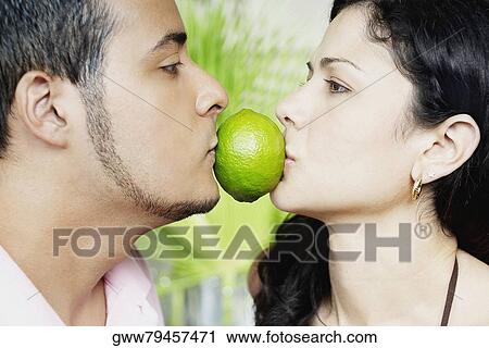Close-up of a young couple holding a lemon between their mouths View Large Photo Image Stock Image - Close-up of a young couple holding a lemon between their mouths. Fotosearch