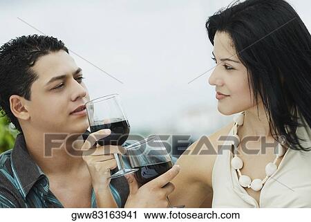 Close-up of a young couple holding glasses of wine View Large Photo Image Stock Image - Close-up of a young couple holding glasses of wine. Fotosearch