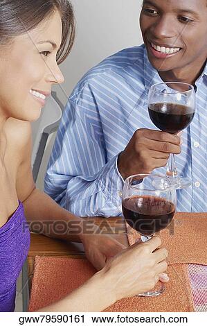 Close-up of a young couple sitting and holding glasses of wine View Large Photo Image Stock Image - Close-up of a young couple sitting and holding glasses of wine. Fotosearch
