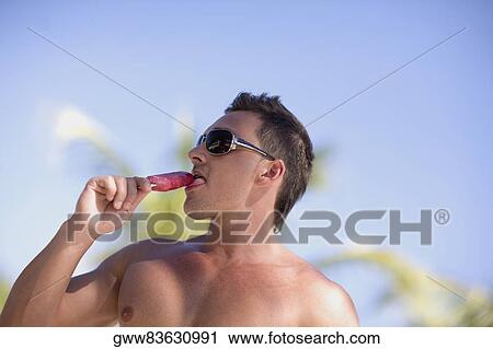 Close-up of a young man eating an ice-cream View Large Photo Image Stock Image - Close-up of a young man eating an ice-cream. Fotosearch