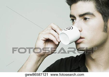 Close-up of a young man holding a cup of tea View Large Photo Image Stock Image - Close-up of a young man holding a cup of tea. Fotosearch
