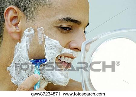 Close-up of a young man shaving in the bathroom View Large Photo Image Stock Image - Close-up of a young man shaving in the bathroom. Fotosearch