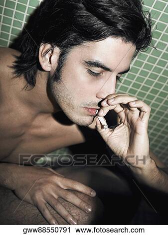 Stock Image - Close-up of a young man smoking a cigarette. Fotosearch