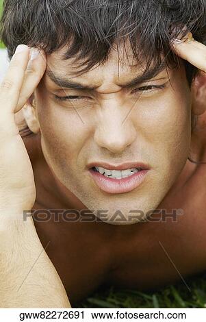 Close-up of a young man suffering from a headache View Large Photo Image Stock Image - Close-up of a young man suffering from a headache. Fotosearch
