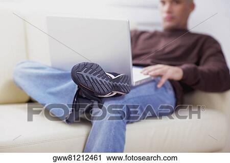 Stock Image - Close-up of a young man using a laptop. Fotosearch