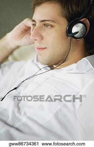 Close-up of a young man wearing headphones View Large Photo Image Stock Image - Close-up of a young man wearing headphones. Fotosearch