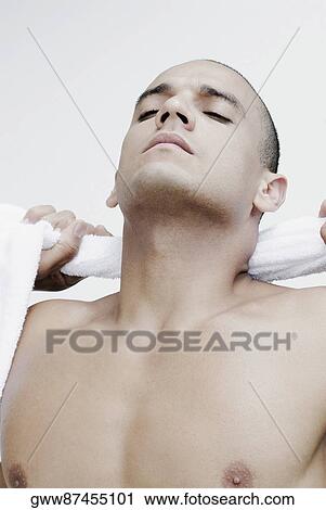 Close-up of a young man wiping his neck with a towel View Large Photo Image Stock Image - Close-up of a young man wiping his neck with a towel. Fotosearch