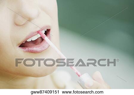 Close-up of a young woman applying lip liner View Large Photo Image Stock Image - Close-up of a young woman applying lip liner. Fotosearch