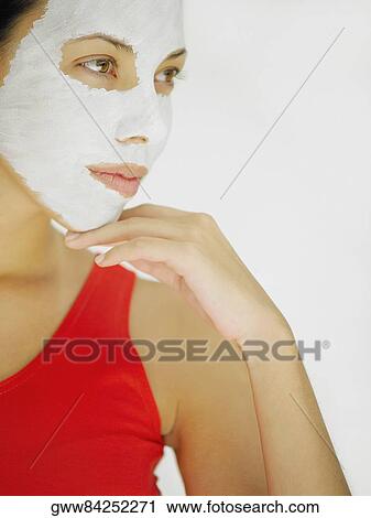 Close-up of a young woman applying facial mask on her face View Large Photo Image Stock Image - Close-up of a young woman applying facial mask on her face. Fotosearch