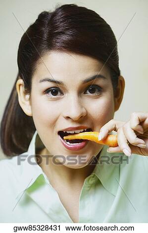Close-up of a young woman eating a carrot View Large Photo Image Stock Image - Close-up of a young woman eating a carrot. Fotosearch