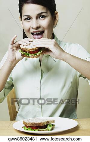 Stock Image - Close-up of a young woman eating a sandwich. Fotosearch