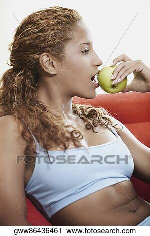 Close-up of a young woman eating an apple View Large Photo Image Stock Image - Close-up of a young woman eating an apple. Fotosearch