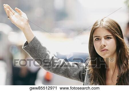 Close-up of a young woman hailing a taxi View Large Photo Image Stock Image - Close-up of a young woman hailing a taxi. Fotosearch