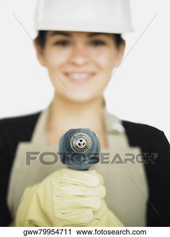 Stock Image - Close-up of a young woman holding a drill. Fotosearch