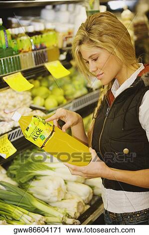 Close-up of a young woman holding a bottle of cooking oil View Large Photo Image Stock Image - Close-up of a young woman holding a bottle of cooking oil. Fotosearch