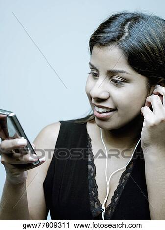 Close-up of a young woman listening to music View Large Photo Image Stock Image - Close-up of a young woman listening to music. Fotosearch