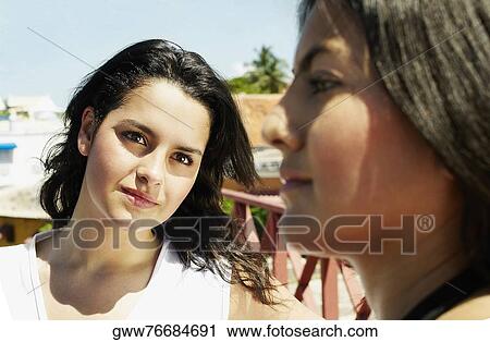 Close-up of a young woman looking at her friend View Large Photo Image Stock Image - Close-up of a young woman looking at her friend. Fotosearch