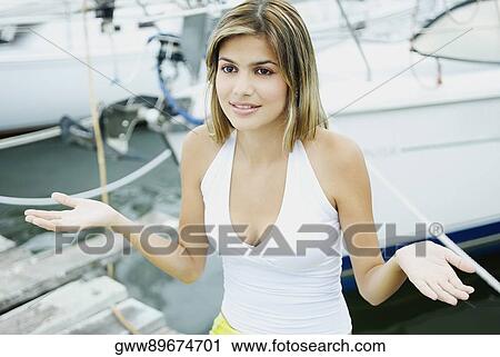 Close-up of a young woman standing at a dock and gesturing View Large Photo Image Stock Image - Close-up of a young woman standing at a dock and gesturing. Fotosearch